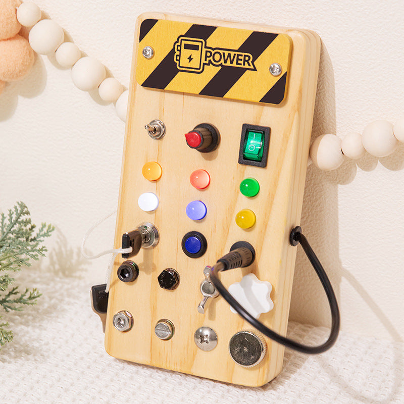 Wooden LED Busy Board Creative Toys A close-up of a toddler's hand toggling a colorful switch on an illuminated wooden sensory toy